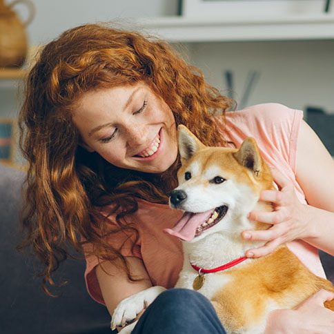 Woman sitting on a couch with shiba inu